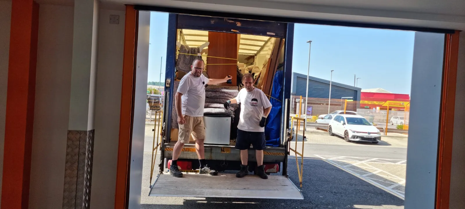 Two-man crew loading heavy items into the van